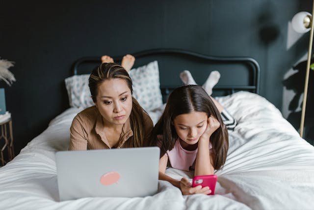 Mutter und Tochter mit Laptop und Smartphone